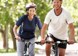 Middle Aged couple happy with health insurance, riding bikes